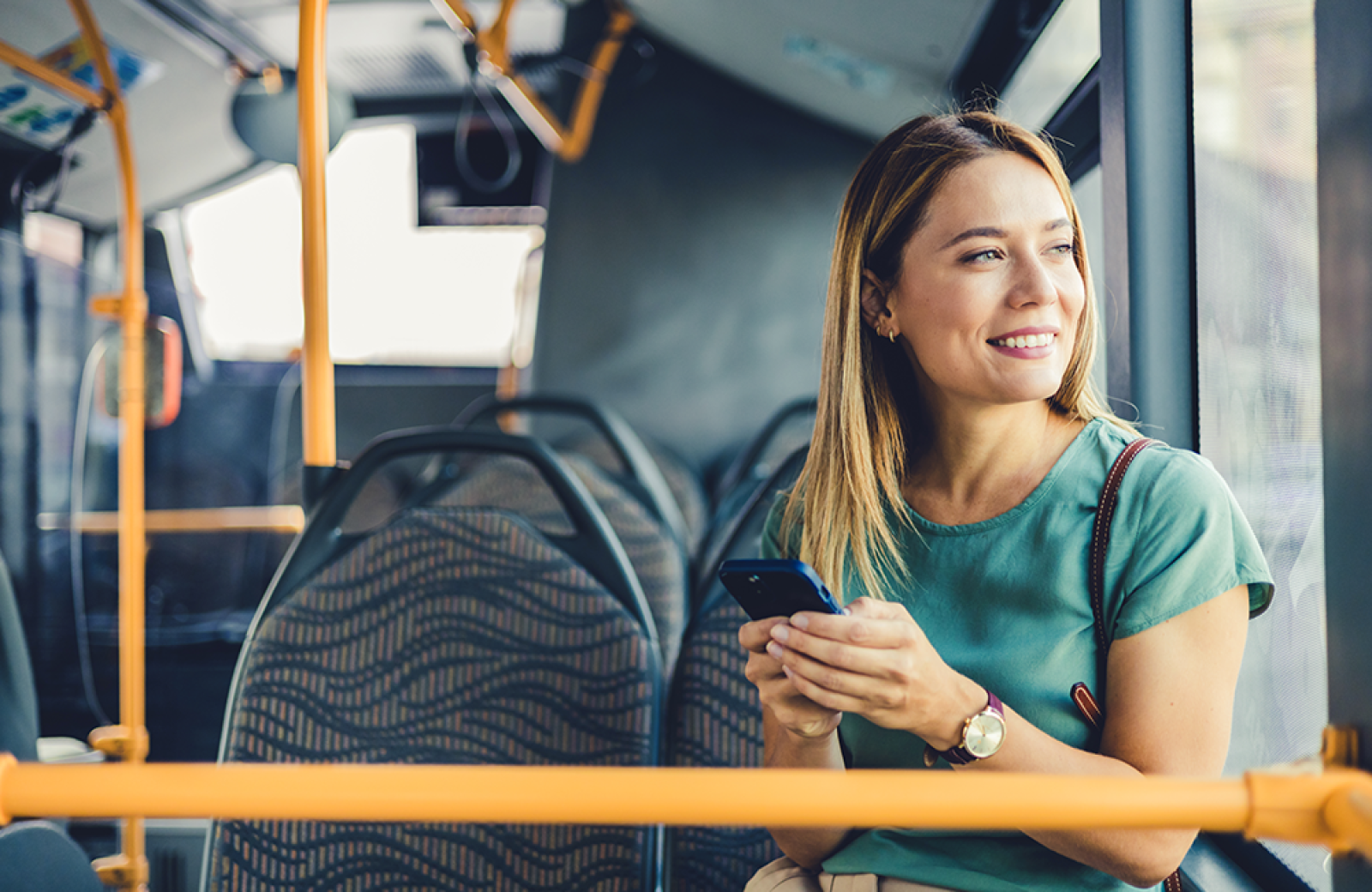 A smiling woman on a bus