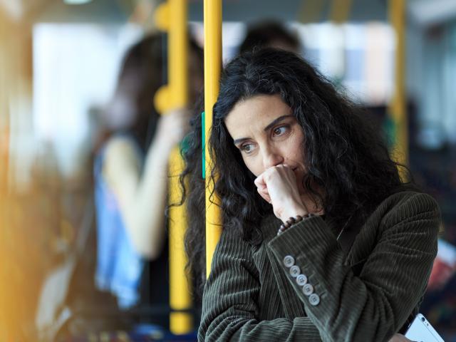 A women looking concerned on a bus