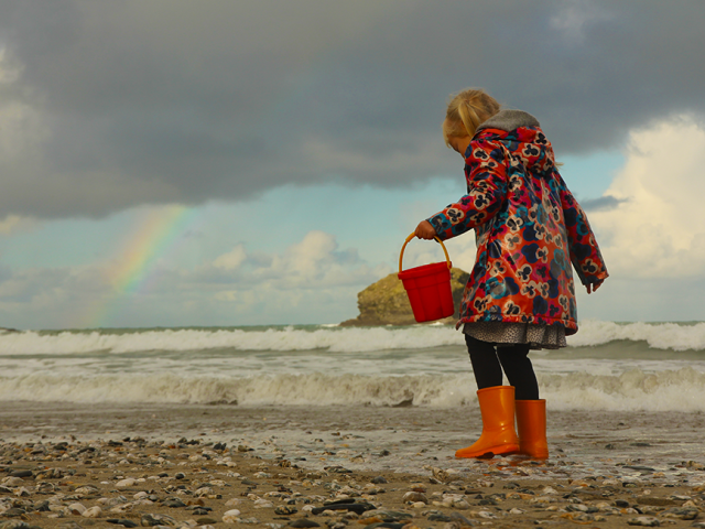 Child on beach with rainbow
