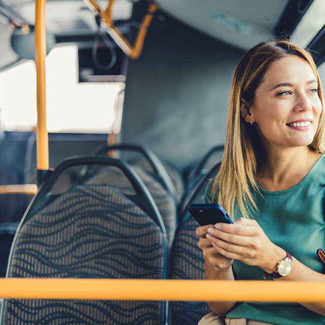 A smiling woman on a bus