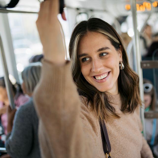 A lady smiling on the bus